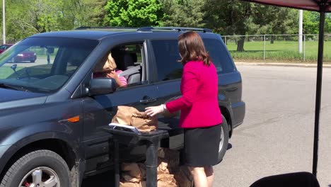 Michigan-Governor-Gretchen-Whitmer-handing-out-food-during-Covid-19-pandemic-in-Lansing,-Michigan