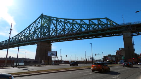 Cars-and-Bus-Traffic-Under-Jacques-Cartier-Steel-Bridge-Montreal-City-Canada,-Urban-Rigid-Metallic-Elevated-Structure-for-Transportation,-Architectural-Infrastructure-and-Engineering