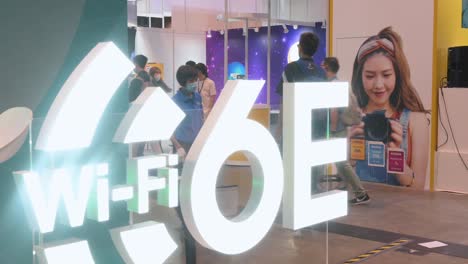 Chinese-visitors-walk-past-a-booth-displaying-6E-Wifi-high-speed-internet-logo-during-the-Hong-Kong-Computer-and-Communications-Festival-in-Hong-Kong