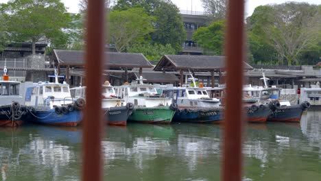 View-Through-Steel-Fence-Of-Bumboats-Parked-At-The-Changi-Jetty-In-Singapore