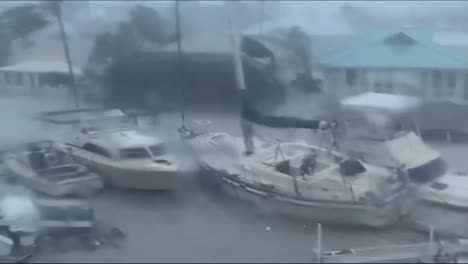 Hurrikan-Ian-In-Florida-Mit-Yachten,-Die-An-Häusern-Vorbeifahren-Und-Durch-Eine-Glasscheibe-Mit-Starkem-Wind-Schauen