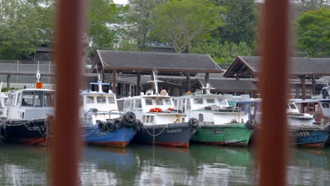 Looking-Through-The-Metal-Grills-With-Bumboats-Moored-At-The-Changi-Village-Jetty-In-The-Background-In-Singapore