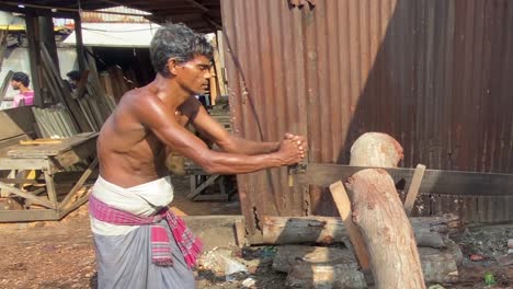 Shirtless-Male-Bangladeshi-Wearing-Longyi-Using-Logging-Saw-In-Timber-Yard