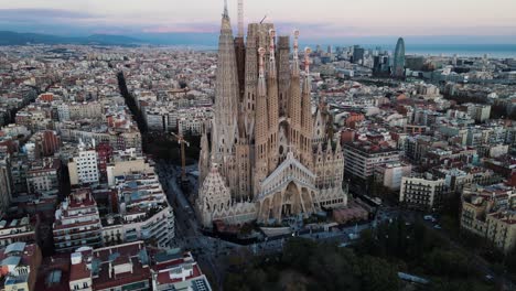 Aerial-panning-shot-of-Barcelona-Spain-with-a-beautiful-view-of-the-famous-Sagrada-Familia-Basilica-Church-during-dawn