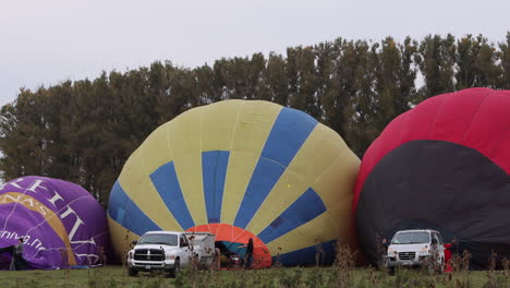 Three-hot-air-balloons-being-inflated,-preparing-for-takeoff