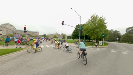 Chicago-cyclists-entering-Museum-of-Science-and-Industry-rest-stop-and-festival-area-during-Bike-the-Drive-2022-porta-pottys-and-neoclassical-building-crowd