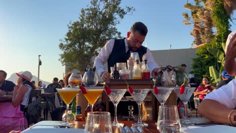 Tableside-service-staff-preparing-and-pouring-fresh-cocktails-at-Nusret-Salt-Bae-restaurant-in-Yalikavak-port,-luxury-dining-experience-at-a-famous-restaurant-in-Bodrum-Turkey,-4K-shot