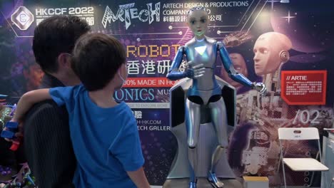 Ein-Vater-Und-Sein-Sohn-Interagieren-Mit-Einem-Automatisierten-Humanoiden-Roboter-Mit-Künstlicher-Intelligenz,-Der-Während-Des-Computer--Und-Kommunikationsfestivals-In-Hongkong-Ausgestellt-Wurde