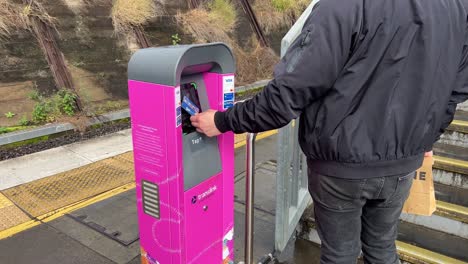 Male-passenger-tapping-on-at-the-ticketing-machine-at-Bowen-Hills-train-station,-using-go-card-to-pay-for-concession-fare,-Brisbane-Queensland,-Australia