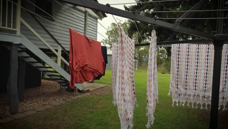 Pull-back-from-washing-on-Hills-Hoist-clothesline-in-Queenslander-backyard