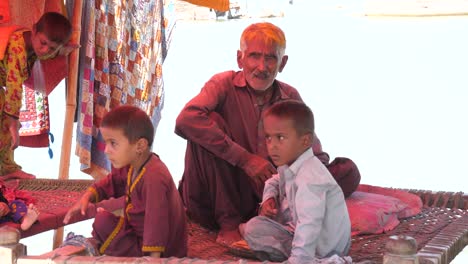 Familia-Sentada-En-Una-Tienda-De-Campaña-En-El-Campamento-De-Ayuda-Contra-Inundaciones-En-Maher,-Sindh