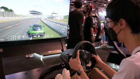 A-Chinese-gamer-plays-a-themed-racing-videogame-as-visitors-attend-the-Hong-Kong-Computer-and-Communications-Festival-in-Hong-Kong