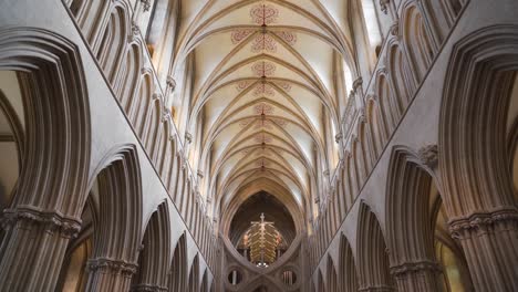 Wells-Cathedral-ceiling-arches,-camera-moving-down-from-the-ceiling-to-the-wooden-benches-showing-the-intricate-columns