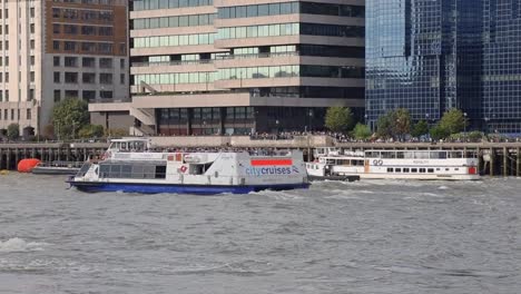 London-City-cruise-ferry-travelling-along-the-river-Thames-below-modern-waterfront-apartment-offices