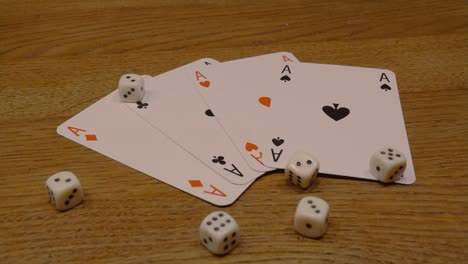 Rotating-close-up-of-playing-cards-with-playing-dice-on-an-elegant-wooden-table-slow-rotation-of-camera