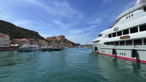 Big-luxury-yacht-moored-at-Bonifacio-harbour-with-castle-and-citadel-perched-on-cliff