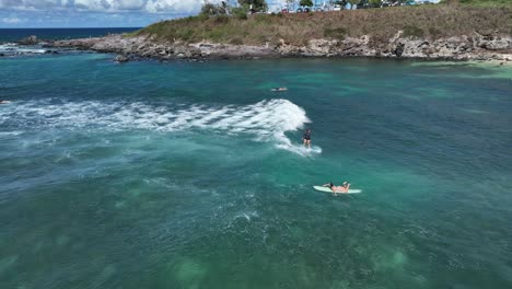 Female-surfer-riding-wave-into-shore,-dives-for-another-set,-Hookipa-Beach-Maui