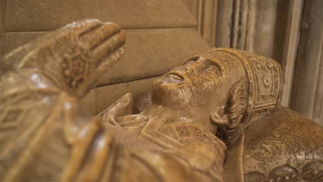 Close-up-on-one-of-the-vandalised-effigies-of-the-Saxon-bishops-of-the-wells-cathedral,-camera-rotating-to-the-right-showing-the-face-of-the-effigy
