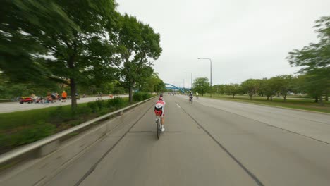 Chicago-cyclists-riding-northbound-on-DuSable-Lake-Shore-Drive-during-Bike-the-Drive-2022-red-triathlon-triathlete-time-trial-bike-appearing-into-screen-south-side-blue-pedestrian-bridge