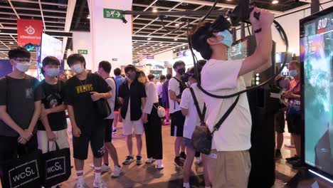 Junge-Chinesische-Gamer-Und-Besucher-Spielen-Während-Des-Computer--Und-Kommunikationsfestivals-In-Hong-Kong-Virtual-reality-multiplayer-shooting-videospiele