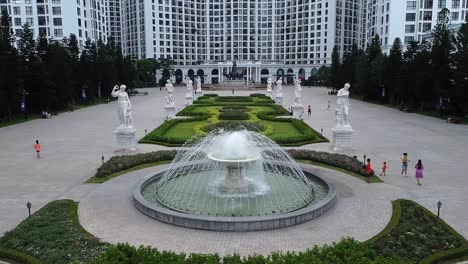 Aerial-Flying-Over-Garden-Fountain-Lined-With-Statues-Outside-Chung-Royal-City-In-Hanoi