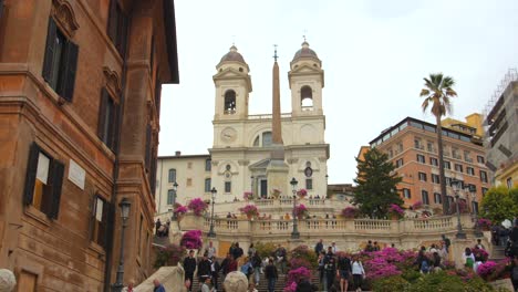 Turistas-Subiendo-Los-Escalones-Españoles-En-La-Piazza-Di-Spagna-Con-El-Obelisco-Sallustiano-Y-La-Iglesia-Trinita-Dei-Monti-Al-Fondo-En-Roma,-Italia