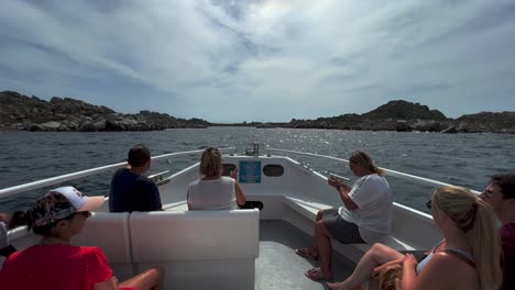Fpv-pov-of-touristic-boat-bow-with-tourist-passengers-onboard-navigating-toward-Lavezzi-island-in-Corsica,-France
