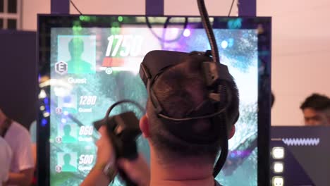A-Chinese-gamer-plays-a-Virtual-Reality-shooting-videogame-as-he-reloads,-points-and-shoots-at-a-target-during-the-Hong-Kong-Computer-and-Communications-Festival-in-Hong-Kong