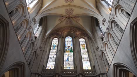 Die-Deckenbögen-Der-Wells-Kathedrale,-Eine-Kamera,-Die-Sich-Von-Der-Decke-Nach-Unten-Bewegt-Und-Die-Verdorbenen-Glasfenster-Zeigt