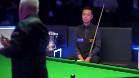 John-Higgins,-a-Scottish-professional-snooker-player,-makes-a-play-as-he-strikes-a-ball-during-a-match-of-the-Hong-Kong-Masters-snooker-tournament-event