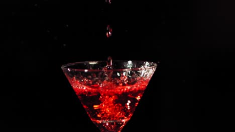A-red-liquid-is-poured-into-a-martini-glass