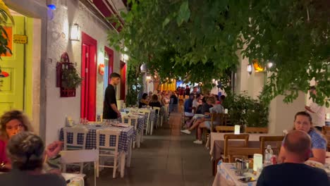 Caminando-Por-Una-Hermosa-Y-Pequeña-Calle-De-Restaurantes-En-Bodrum,-Turquía,-Paseo-Turístico-Nocturno-Por-La-Ciudad,-Toma-De-4k