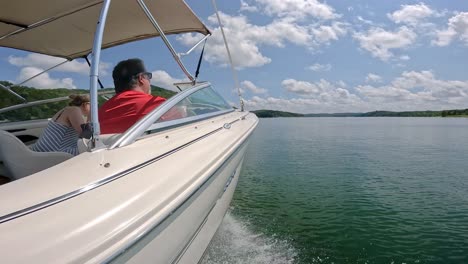 A-couple-cruising-in-their-sports-boat-with-the-canopy-raised-while-cruising-on-Table-Rock-in-Missouri-USA