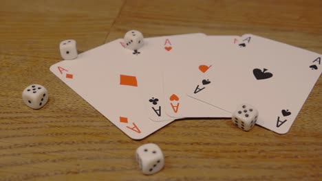 Schwenk-über-Pokerkarten-Mit-Spielwürfeln-Auf-Einem-Edlen-Und-Hochwertigen-Holztisch-In-Langsamer-Kamerafahrt