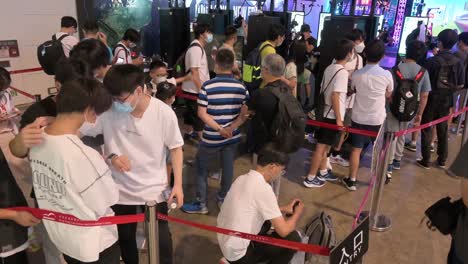 Chinesische-Gamer-Und-Junge-Besucher-Stehen-Während-Des-Computer--Und-Kommunikationsfestivals-In-Hong-Kong-In-Der-Schlange,-Um-Virtual-reality-shooting-videospiele-Zu-Spielen
