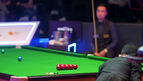A-referee-adjusts-the-balls-to-start-a-new-set-as-a-professional-snooker-match-is-ongoing-during-the-Hong-Kong-Masters-snooker-tournament-event