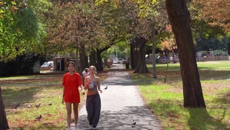 A-couple-of-young-girls-walking-through-Wanstead-green-shaded-by-the-trees