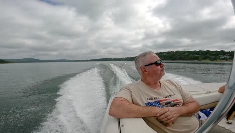 Slow-motion---Man-enjoying-life-in-back-of-sports-boat-cruising-on-Table-Rock-Lake-in-the-Ozark-Mountains-of-Missouri-USA