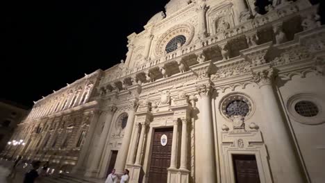 Tilt-down-night-scene-of-illuminated-baroque-church-of-Santa-Croce-in-Lecce,-Italy