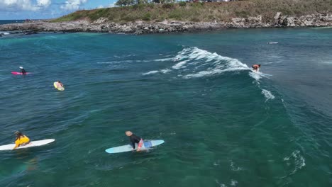 Surfers-paddle-out,-sit-on-surfboard,-read-ocean-to-catch-next-set,-Hookipa-Maui