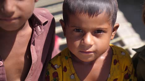 Nahaufnahme-Eines-Kleinen-Mädchens-In-Gelbem-Kleid,-Das-An-Einem-Sonnigen-Tag-In-Pakistan-In-Die-Kamera-Blickt