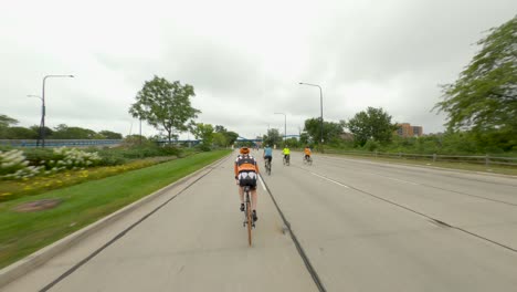 Chicago-cyclists-riding-southbound-on-DuSable-Lake-Shore-Drive-during-Bike-the-Drive-2022-orange-bike-and-gear-bike-rider-pedestrian-bridge