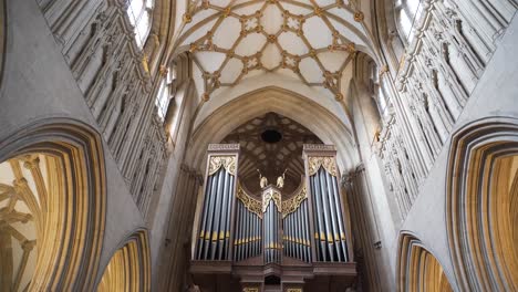 Wells-Cathedral-ceiling-arches,-camera-moving-down-from-the-ceiling-and-revealing-the-pipe-organ
