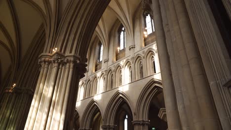 Wells-Cathedral-ceiling-arches,-camera-rotating-to-the-left-showing-the-intricate-columns-and-small-windows
