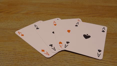Panning-shot-of-poker-cards-with-ace-of-spades-each-in-black-and-in-red-on-a-high-quality-wooden-table