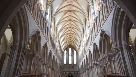Wells-Cathedral-ceiling-arches,-camera-moving-down-from-the-ceiling-to-the-woden-benches