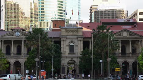 Static-shot,-front-facade-of-heritage-building-Brisbane-GPO-post-office-at-busy-central-business-district,-office-workers-rushing-home,-walking-through-laneway,-car-traffic-crossing-on-Queen-street