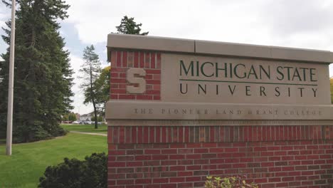 Michigan-State-University-in-East-Lansing,-Michigan-sign-with-video-panning-left-to-right