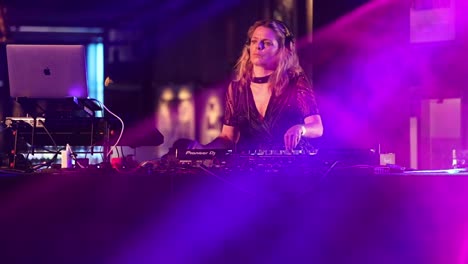 Blond-Female-DJ-Swaying-While-Performing-In-The-Concert-Stage-In-Under-The-Bridge,-London,-UK