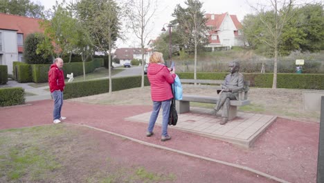 Mujer-Tomando-Una-Foto-Con-Un-Teléfono-Inteligente-De-La-Famosa-Estatua-De-Albert-Einstein-En-La-Ciudad-Costera-De-De-Haan,-Bélgica